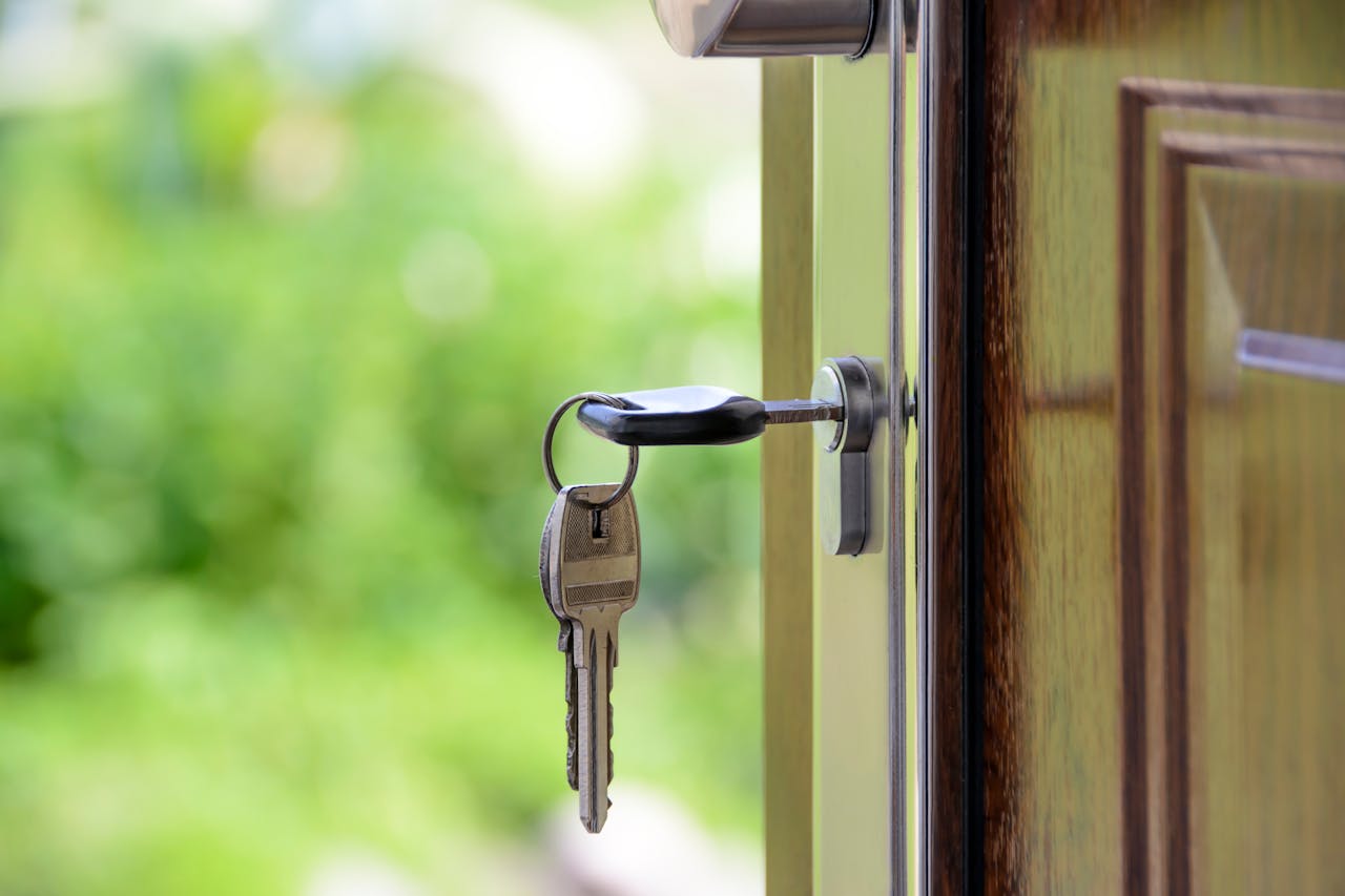 get-in-touch Key inserted in door lock against a blurred green background, symbolizing security and real estate.