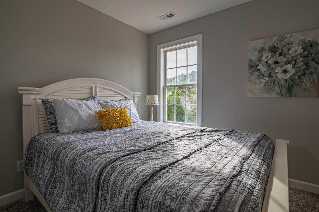 services-06 A warm, inviting bedroom with a double bed and natural light streaming in.